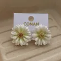 Chic white daisy stud earrings with shimmering petals and yellow centers on a display card - White Green