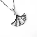 Gros plan d'un pendentif feuille de ginkgo argenté avec détails des nervures sur une chaîne - Feuille de Ginkgo + Chaîne en Acier Inoxydable