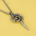 Detailed view of vintage snake scepter totem pendant with etched black patterns - Scepter + Steel Chain
