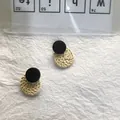 Detail of vintage round woven rattan earrings with black studs on textured paper background - Rattan Diameter 3cm / Black