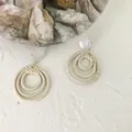 Detail of bohemian cream woven drop earrings with three-tier concentric straw circles - Concentric Rings Style 2