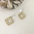 Square woven rattan earrings with white resin top studs on a minimalist textured surface - Square Hollow Style