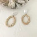 Detailed view of handmade rattan drop earrings with white resin studs on a textured background - Oval Woven Style 9