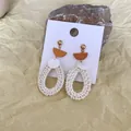 Macro view of bohemian woven rattan teardrop earrings with golden studs on natural stone - Orange Half-Circle Beige Rattan Teardrop (B34)