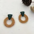 Detail of bohemian rattan earrings with dark green resin triangles on white surface - Round Woven Rattan 65 (Dark Green Top)