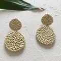 Detailopname van handgemaakte ronde rotan oorbellen met boho gevlochten ontwerp - Beige (Licht)