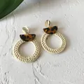 Detail of bohemian round straw woven earrings with leopard resin and gold studs - New Rattan Woven 50 (Leopard Top, Off-white Ring)
