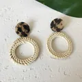 Close-up of geometric rattan drop earrings with leopard print resin and straw weaving - New Rattan Woven 43 (Circular Rattan with Tortoiseshell Top)