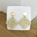 Bohemian geometric straw woven earrings with golden metal studs on a wooden background - Light Color Solid Square Rattan