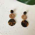 Close-up of bohemian three-tier earrings featuring resin tortoise shell and woven rattan rings - Long Dark Leopard