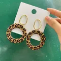 Macro-opname van luipaardprint rotan oorbellen met een gouden metalen verbindingsring - Luipaardprint Geweven B79-3
