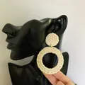 Detail of bohemian rattan drop earrings showing woven texture on a black model bust - New Rattan Woven 18 (Off-White Double Round Weave)