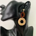 Handmade woven rattan geometric pendant earrings with gold studs on a model - Dark Color Rattan (B88)