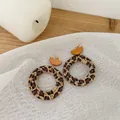 Macro shot of handmade leopard print rattan earrings on textured white fabric - Brown Wood Grain Earhook Style (Style 4)