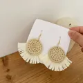 Detail of bohemian handmade rattan earrings with white raffia tassels and gold hooks - Light Color Round Disc Rattan (A84)