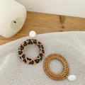 Detailed macro shot of large round hand-woven rattan earrings with leopard print accents - White Round Bead Stud Style (Style 5)