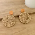Close-up of Bohemian hand-woven rattan earrings with circular walnut-colored wood studs - New Style Rattan 28 (Walnut Wood Round Top)