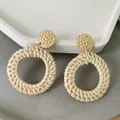 Close-up of bohemian wicker drop earrings featuring golden hammered metal studs and woven rings - New Woven Rattan 14 (Cream Woven Ring)