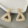 Detailed shot of bohemian beige rattan woven triangle earrings with gold hammered metal studs - Light Triangle Style (A81)