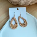 Detailed view of handmade teardrop straw earrings with natural woven texture and gold hooks - Hollow Waterdrop Woven Style (B22)