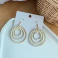 Detail of bohemian triple nested concentric circle woven rattan earrings on display card - Triple Ring Woven Style (B24-3)