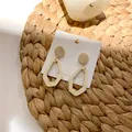 Retro geometric hollow pentagon drop earrings with beige wooden texture on display - Beige Style