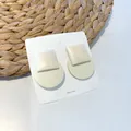 Detail of square cream and round pale green geometric wooden earrings on white display card - Square and Round Patchwork Style / Off White