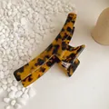 Close-up of large tortoiseshell acetate hair claw clip with a secure metal spring - Dark Leopard Print