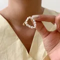 Detailopname van een parelring met een verfijnde goudkleurige letter J bedel hanger - Letter J (Natuurlijke Parelring)