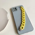 Detail of blue silicone phone case with chunky yellow acrylic chain and metal rivets - Yellow