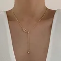 Elegante gouden Y-vormige ketting met zirkoon varkensneus hanger bij een vrouwelijk model - Varkensneus Hanger Ketting / Goud