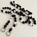Detail of black and white beaded phone strap with silver Love tag and metal rings - Black and White (G234)