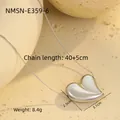 Nahaufnahme des polierten 3D-Herzanhängers an feiner Kette auf strukturiertem Stein - 18K Reinheit / Stahlfarbenes Herz (NMSN-E359-6)
