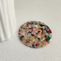 Dettaglio di uno specchio da tasca tondo in acetato con motivi terrazzo colorati - Colorato
