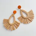 Macro detail of Bohemian raffia woven earrings with orange studs and grass tassels - Brown Top Teardrop Woven Rattan Brown Raffia Style (B340)