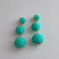 Macro detail of turquoise woven raffia tier earrings with gold bohemian connectors - Turquoise Green