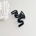 Minimalist matte black wave-shaped hair claw clip with a modern curved design - Black