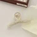Detail van zilveren haarklem met gele kattenoog kralen op een getextureerde achtergrond - Goud
