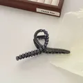 Detail van een elegante zwarte haarklem met imitatieparels en grijze strassteentjes - Zwart