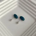 Minimalist dark green oval stud earrings with silver screw backs on white tray - Dark Blue