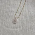 Macro shot of letter G pendant on snake chain with natural white shell inlay detail - Letter G Pendant Necklace
