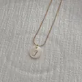 Detail of round shell pendant with golden letter J and fine snake chain necklace - Letter J Pendant Necklace