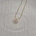 Detailed shot of golden snake chain necklace with natural shell letter L pendant - Letter L Pendant Necklace