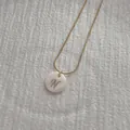Macro detail of golden snake chain necklace featuring a white shell letter N pendant - Letter N Pendant Necklace