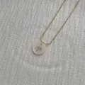 Macro shot of gold snake chain with white shell pendant featuring an engraved letter P - Letter P Pendant Necklace