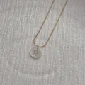Close-up of golden snake chain with a white shell pendant featuring the letter Q - Letter Q Pendant Necklace