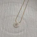 Macro shot of minimalist gold snake chain and round shell pendant with letter R - Letter R Pendant Necklace