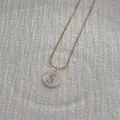 Detailed macro view of a gold snake chain necklace with an S-letter shell pendant - Letter S Pendant Necklace