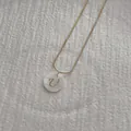 Macro detail of golden snake chain with shell pendant showing letter U engraving - Letter U Pendant Necklace