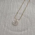 Detailed macro view of letter X shell pendant on a gold snake chain necklace - Letter X Pendant Necklace